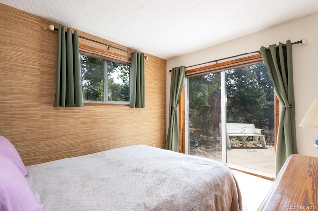 bedroom with a textured ceiling and wood walls