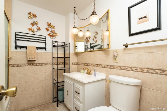 bathroom with vanity, tile walls, and toilet