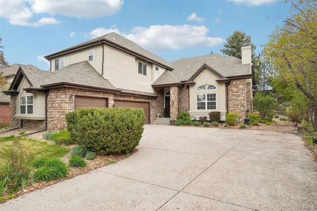 view of front facade featuring stucco siding, driveway, and stone siding