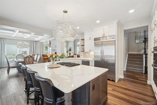 kitchen featuring recessed lighting, appliances with stainless steel finishes, an inviting chandelier, and coffered ceiling