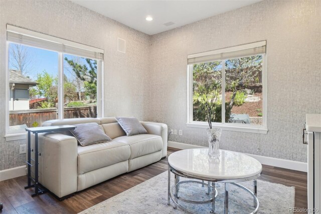 living room with baseboards, plenty of natural light, and dark wood-type flooring