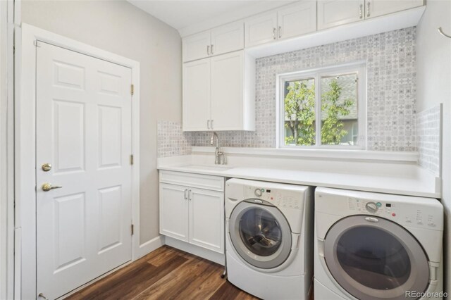 clothes washing area featuring cabinet space, separate washer and dryer, a sink, and dark wood-style flooring