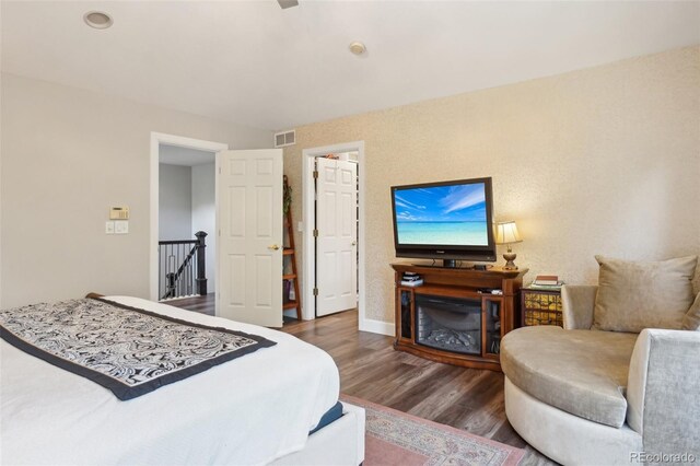 bedroom featuring baseboards, visible vents, and wood finished floors