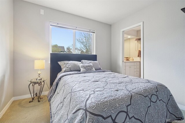 bedroom with baseboards, ensuite bathroom, and carpet