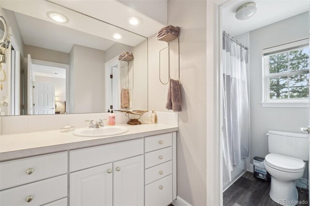 bathroom featuring toilet, a shower with curtain, wood finished floors, and vanity