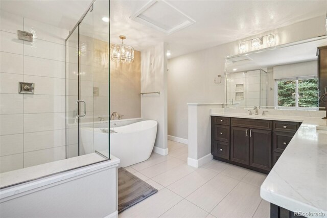 full bath featuring vanity, tile patterned floors, baseboards, a soaking tub, and a stall shower