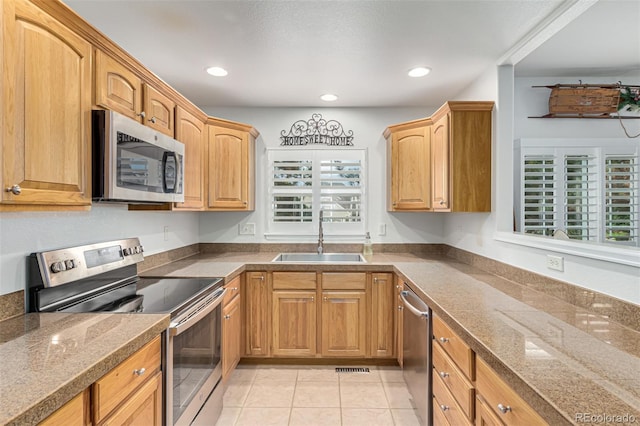 kitchen with appliances with stainless steel finishes, sink, and light tile patterned floors