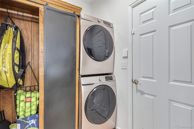 clothes washing area with stacked washing maching and dryer