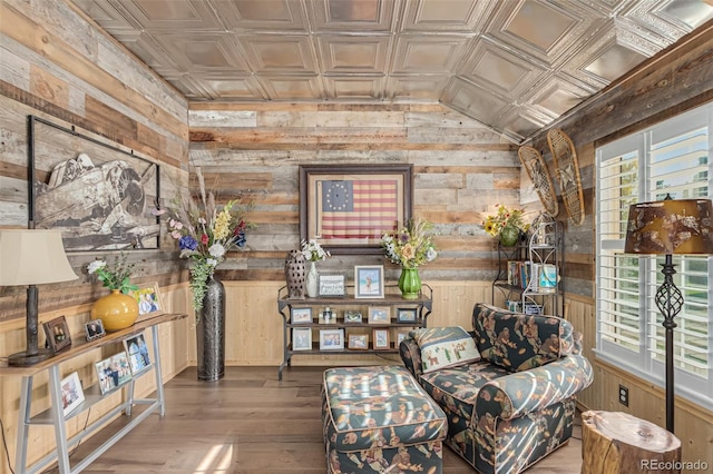 sitting room featuring wood walls, hardwood / wood-style floors, and lofted ceiling