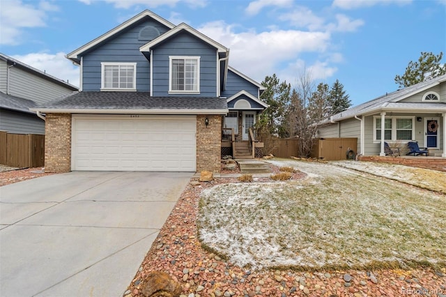 view of front of home with brick siding, an attached garage, concrete driveway, and fence