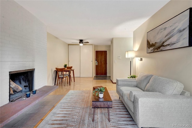 living room featuring ceiling fan and a fireplace