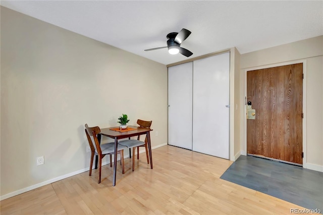 dining room featuring light wood-style flooring, baseboards, and a ceiling fan