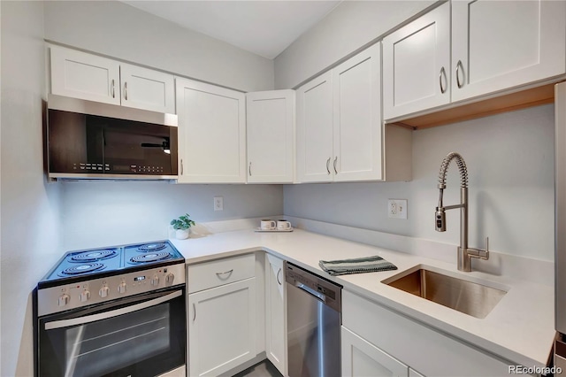 kitchen featuring a sink, stainless steel appliances, light countertops, and white cabinetry