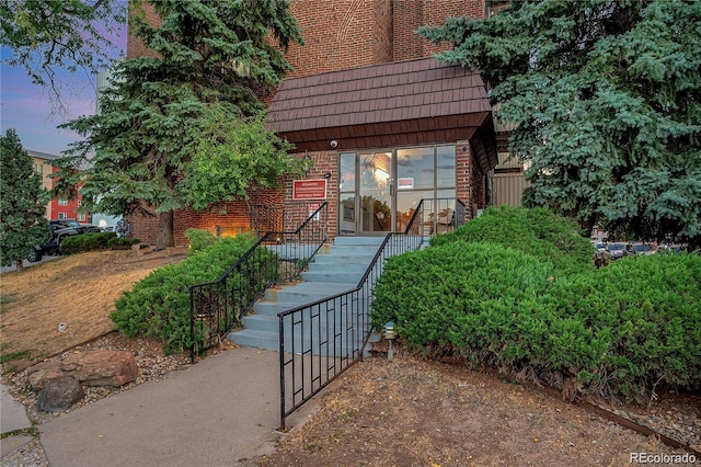 view of front of house featuring stairway and brick siding