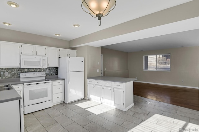 kitchen featuring white cabinetry, light tile patterned floors, kitchen peninsula, tasteful backsplash, and white appliances