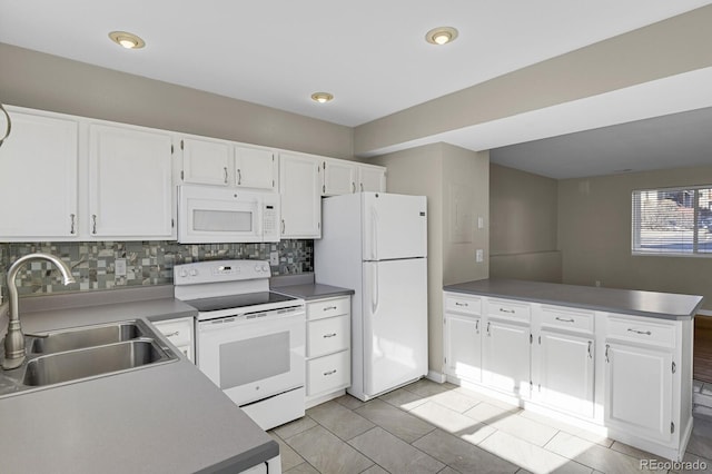 kitchen featuring decorative backsplash, sink, white cabinets, and white appliances