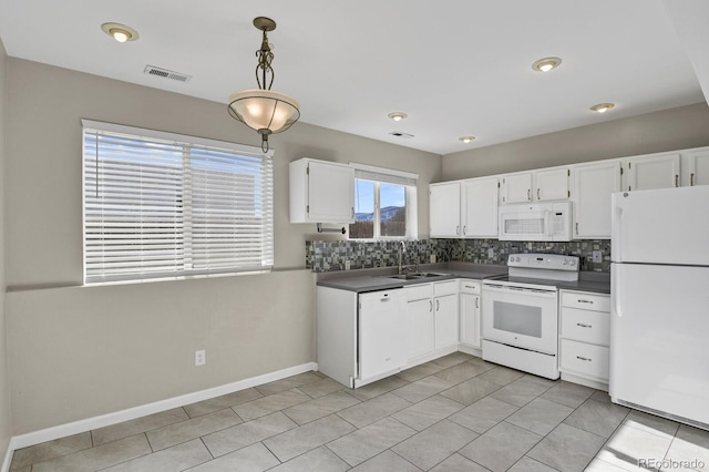 kitchen featuring decorative light fixtures, white cabinets, and white appliances