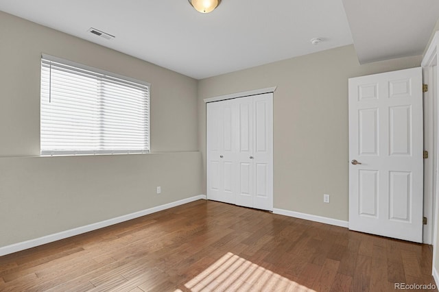 unfurnished bedroom with a closet and wood-type flooring