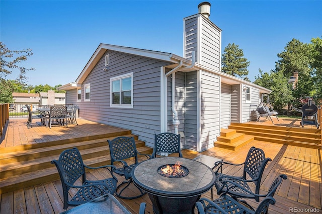 7780 S Kendall Blvd, Littleton, CO 80128 - wooden deck with outdoor dining area and a fire pit