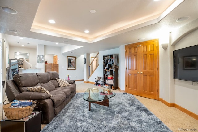 living room with carpet flooring and a tray ceiling