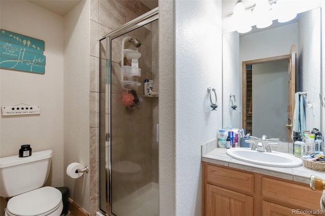 bathroom with vanity, toilet, and an enclosed shower