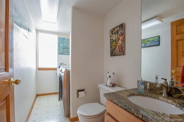 bathroom featuring vanity, toilet, and washer and dryer