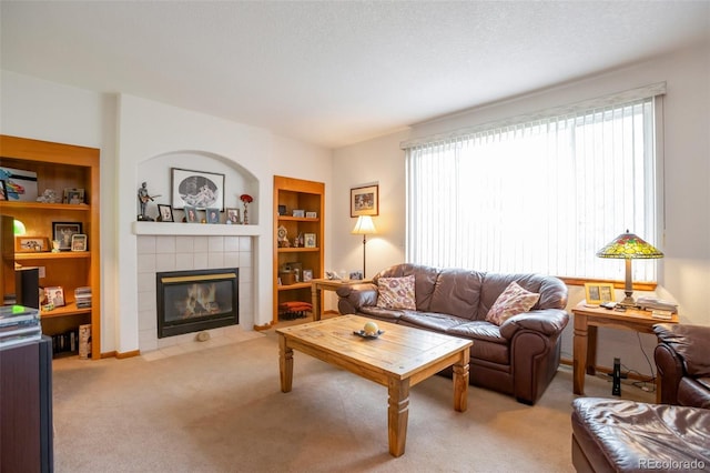 living room with built in features, a textured ceiling, a fireplace, and light carpet