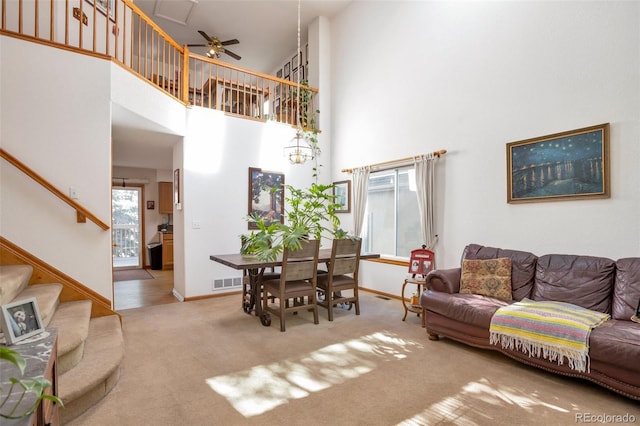 living room featuring carpet flooring, a high ceiling, and ceiling fan