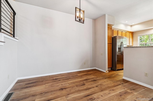 unfurnished dining area with dark hardwood / wood-style flooring and a chandelier