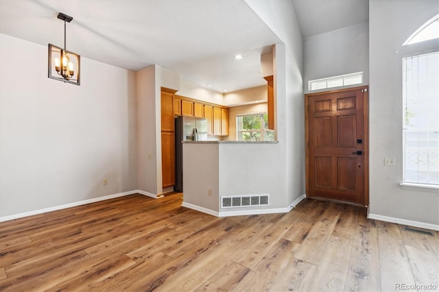 entrance foyer with a notable chandelier and light hardwood / wood-style floors