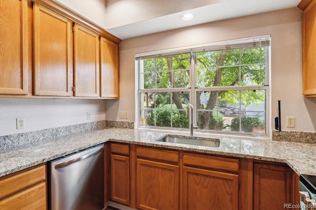 kitchen with dishwasher, light stone countertops, and sink