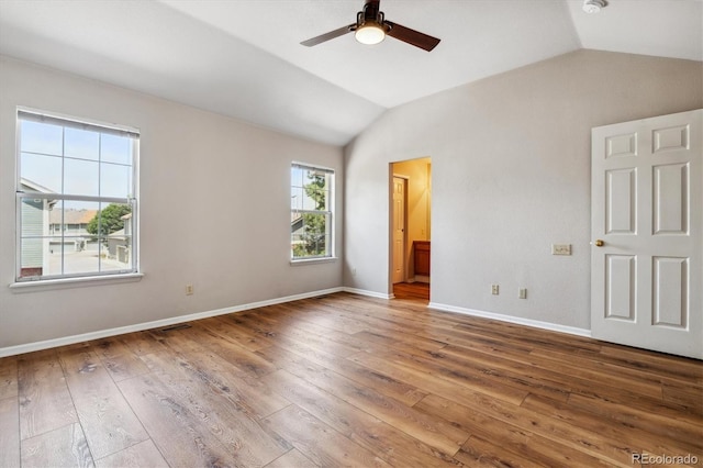 unfurnished bedroom featuring connected bathroom, ceiling fan, wood-type flooring, and lofted ceiling