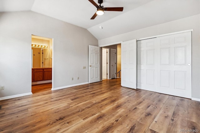 unfurnished bedroom with ensuite bathroom, ceiling fan, lofted ceiling, and light hardwood / wood-style flooring