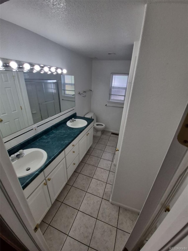 894 S Krameria St, Denver, CO 80224 - bathroom with a textured ceiling, double vanity, tile patterned floors, toilet, and an enclosed shower