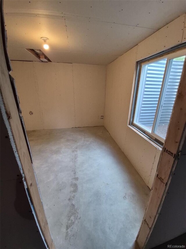 894 S Krameria St, Denver, CO 80224 - empty room featuring unfinished concrete flooring and plenty of natural light