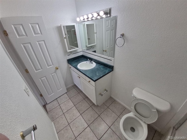 894 S Krameria St, Denver, CO 80224 - bathroom with tile patterned flooring, vanity, toilet, a textured wall, and baseboards