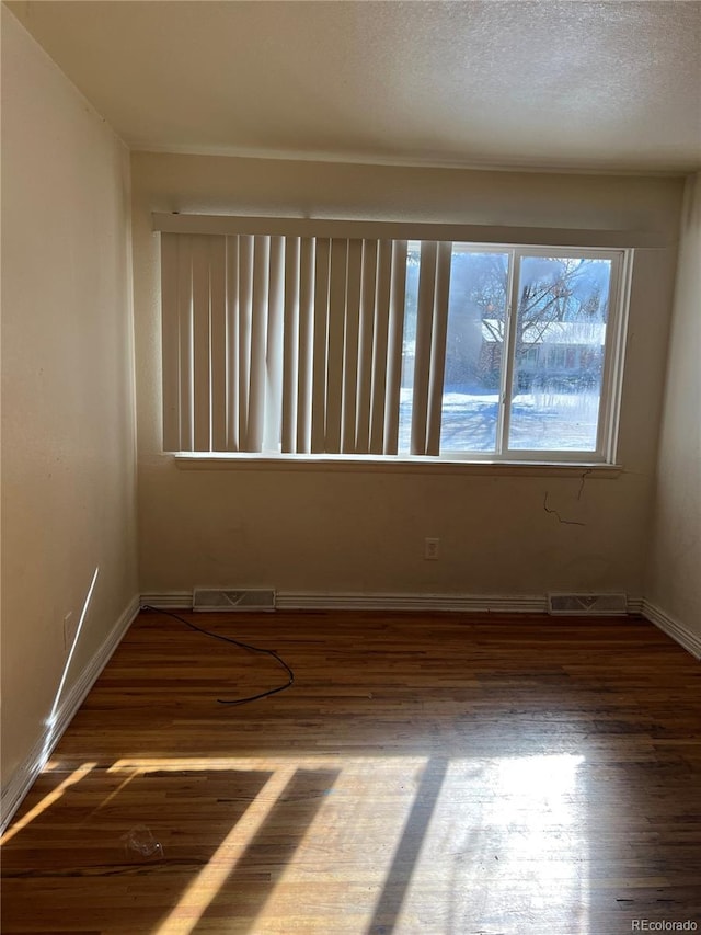 unfurnished room featuring dark hardwood / wood-style floors and a textured ceiling