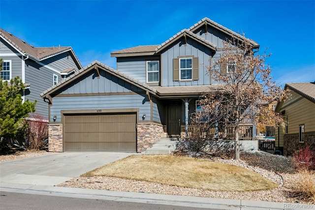 craftsman-style home with a porch, concrete driveway, board and batten siding, a garage, and stone siding