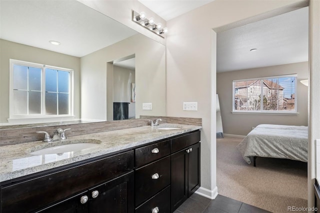 full bath with tile patterned flooring, a sink, baseboards, and double vanity