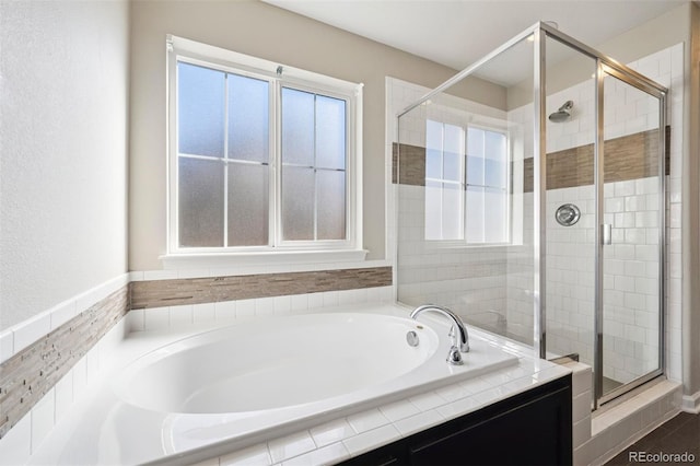 bathroom featuring a stall shower and a bath