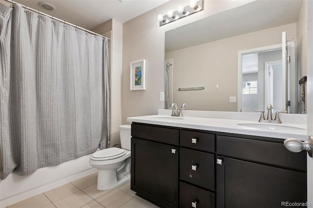 bathroom featuring toilet, tile patterned flooring, double vanity, and a sink