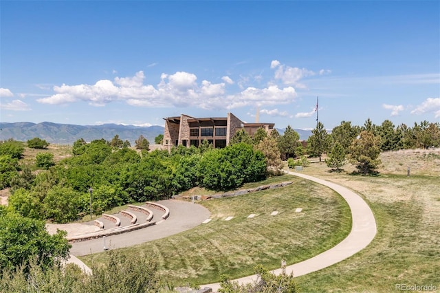 view of community with a mountain view and a lawn