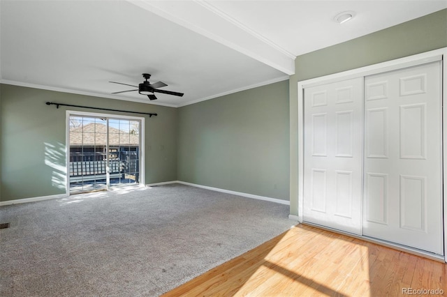 unfurnished bedroom featuring ornamental molding, access to outside, ceiling fan, wood-type flooring, and a closet