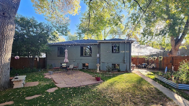 rear view of property with a yard and a patio