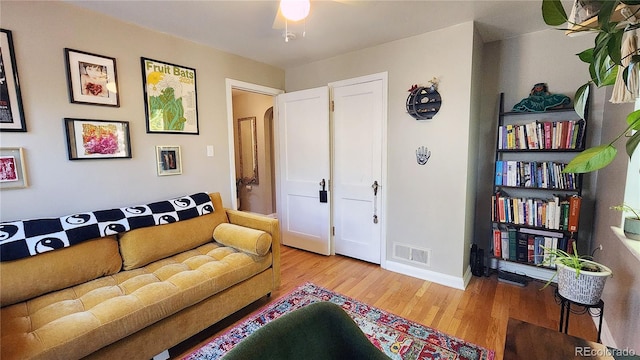 living room featuring ceiling fan and hardwood / wood-style flooring