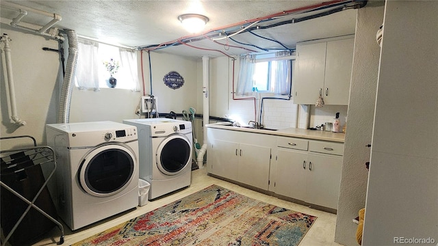 washroom featuring cabinets, washer and clothes dryer, and sink