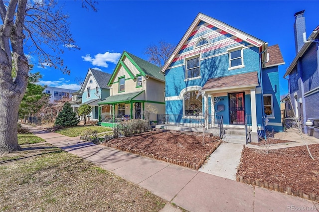 victorian house with a residential view, covered porch, and stucco siding