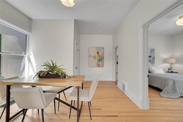 dining area featuring visible vents, baseboards, and light wood-style flooring