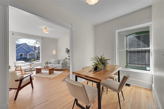 dining room with visible vents, light wood-type flooring, and baseboards