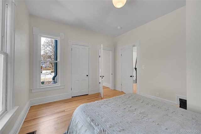 bedroom with visible vents, baseboards, and light wood-style floors